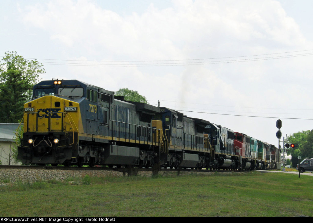 CSX 7379 leads a long train thru town